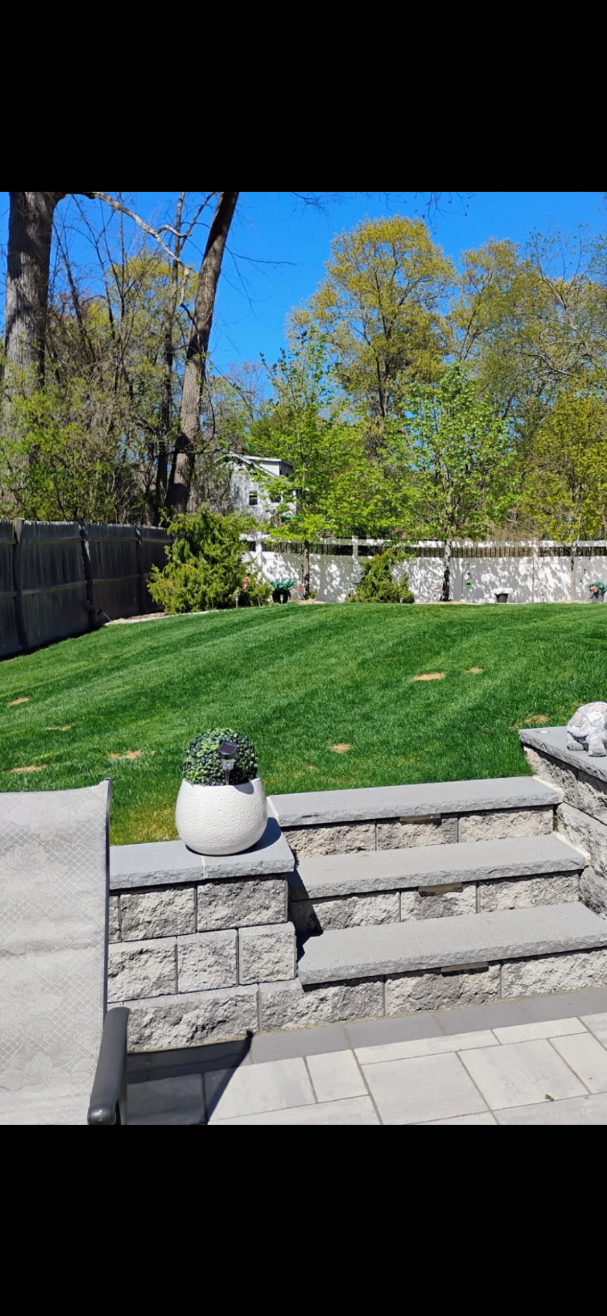 Backyard lawn with clean stonework and steps